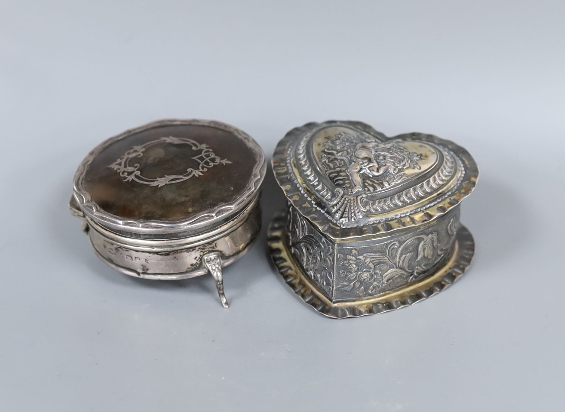 A George V silver and tortoiseshell pique circular trinket box, 71mm and a late Victorian embossed silver heart shaped box, import marks for London, 1888, 80mm.